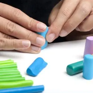 Hands shaping colorful modeling clay pieces